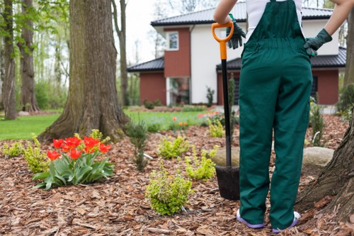 Garden maintenance worker using safe equipment practices